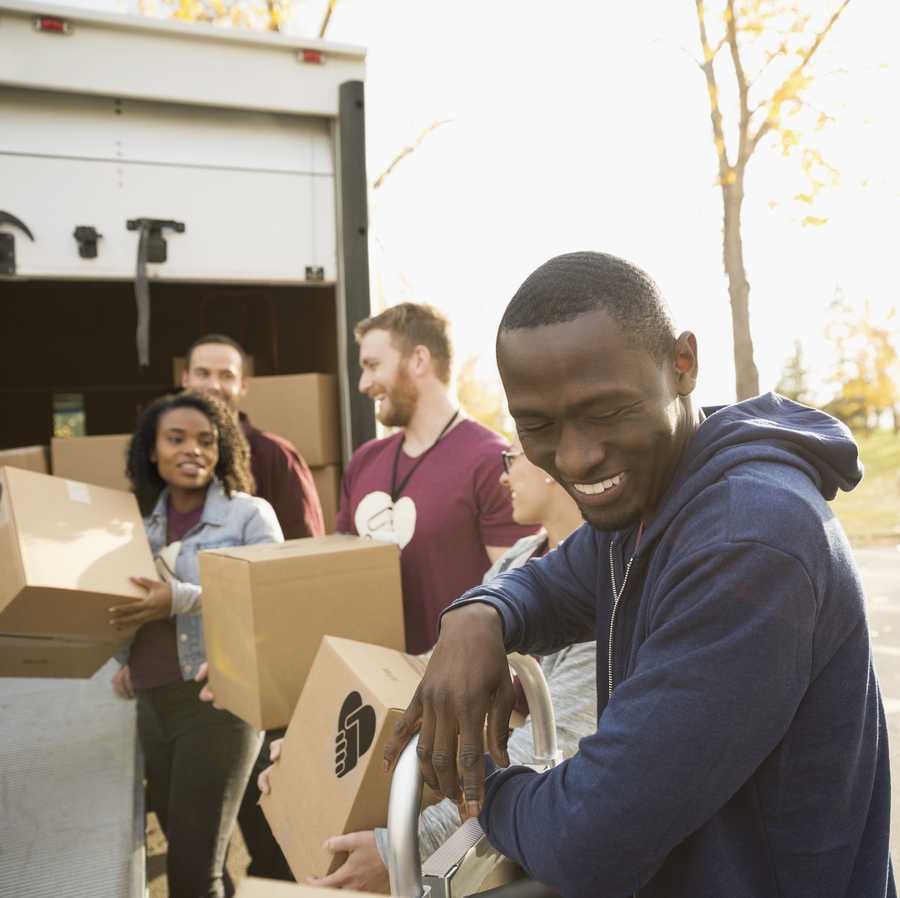 Smiling volunteers unloading cardboard boxes from truck Smiling volunteers unloading cardboard boxes from truck